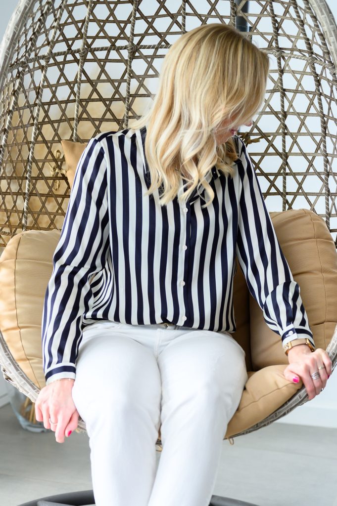 Capsule wardrobe. A woman in black and white stripe shirt and white trousers